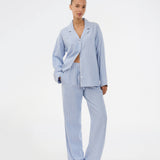 Blue classic striped pyjamas. The pyjamas is sold as a set of shirt and pants in the same size. Josefinemd pyjamas are made from 100% soft cotton and feature a classic fit with a collar, button closure, and drawstring trousers. Finished with delicate wave trim and comes with a matching pouch with logo. Josefine Vogt (165 cm) and the model (177 cm) are both wearing size Small.