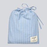 Blue classic striped pyjamas. The pyjamas is sold as a set of shirt and pants in the same size. Josefinemd pyjamas are made from 100% soft cotton and feature a classic fit with a collar, button closure, and drawstring trousers. Finished with delicate wave trim and comes with a matching pouch with logo. Josefine Vogt (165 cm) and the model (177 cm) are both wearing size Small.