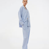 Blue classic striped pyjamas. The pyjamas is sold as a set of shirt and pants in the same size. Josefinemd pyjamas are made from 100% soft cotton and feature a classic fit with a collar, button closure, and drawstring trousers. Finished with delicate wave trim and comes with a matching pouch with logo. Josefine Vogt (165 cm) and the model (177 cm) are both wearing size Small.