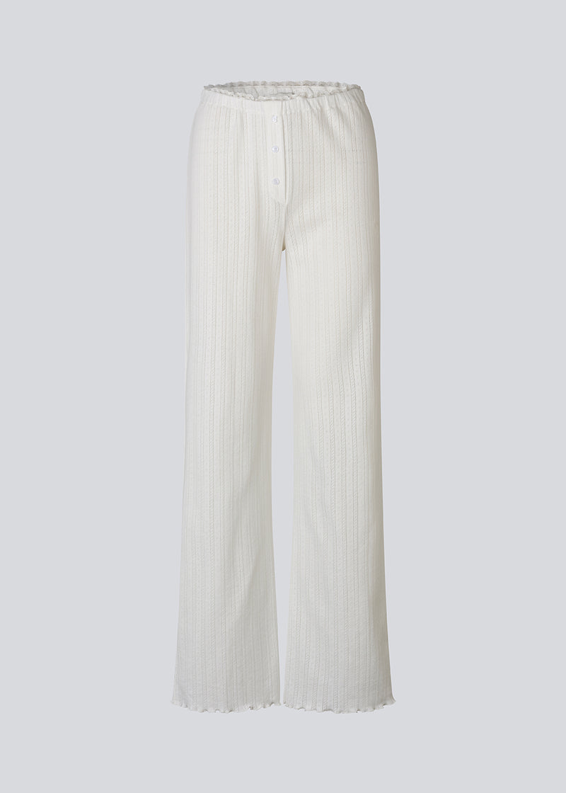 White pointelle pants. Josefinemd pants are feminine pointelle cotton trousers with lace trim and a subtle openwork pattern. Soft, comfortable, and ideal for relaxing at home. Josefine Vogt (165 cm) and the model (177 cm) are both wearing size Small.