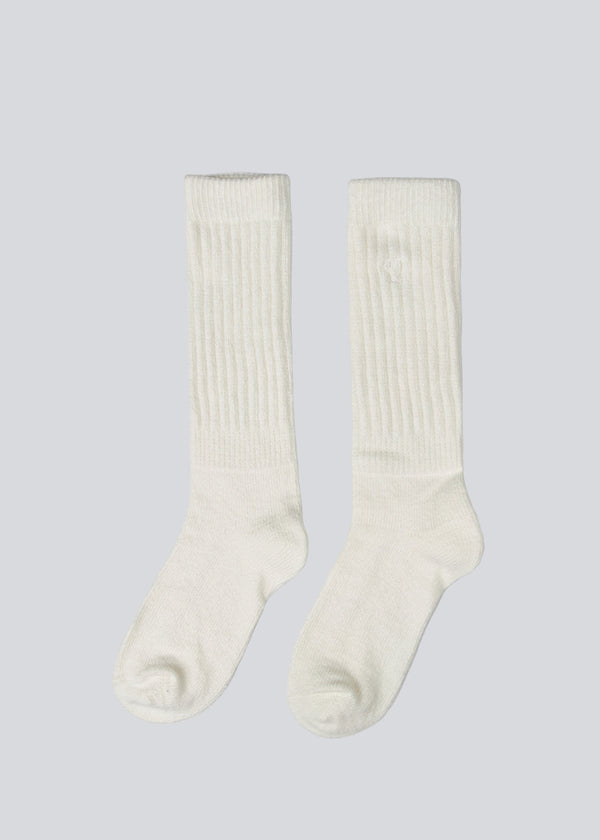 Modström x Josefine Vogt – White knitted Socks. Josefinemd socks are long, soft, and feature a subtle embroidered heart. Perfect for cozy moments at home or on the go.&nbsp;