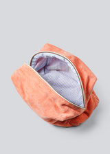 Peach colored toiletry bag with a sewn-on logo. Josefinemd toiletry bag is minimalist and made from organic cotton with a light blue lining and zip closure. Practical and elegant – a must-have for travel or the bathroom.
