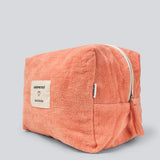 Peach colored toiletry bag with a sewn-on logo. Josefinemd toiletry bag is minimalist and made from organic cotton with a light blue lining and zip closure. Practical and elegant – a must-have for travel or the bathroom.
