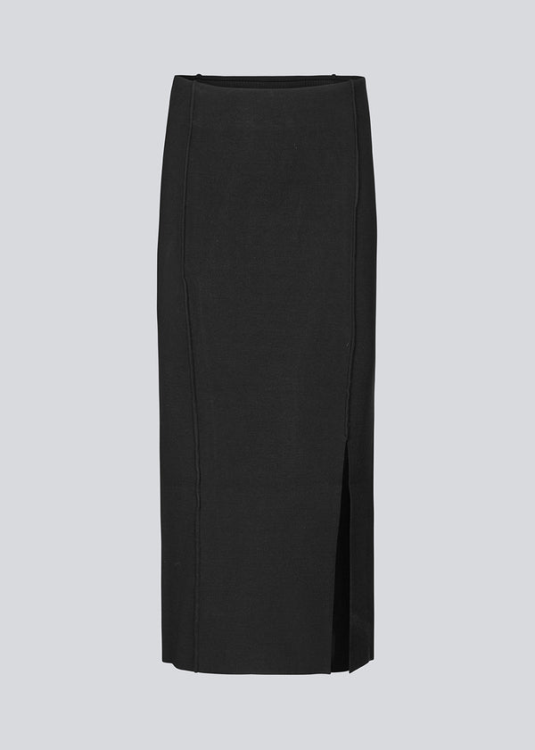 Long black flat knitted skirt with folded details. KaitoMD skirt has an elastic waistband and a slit in front.