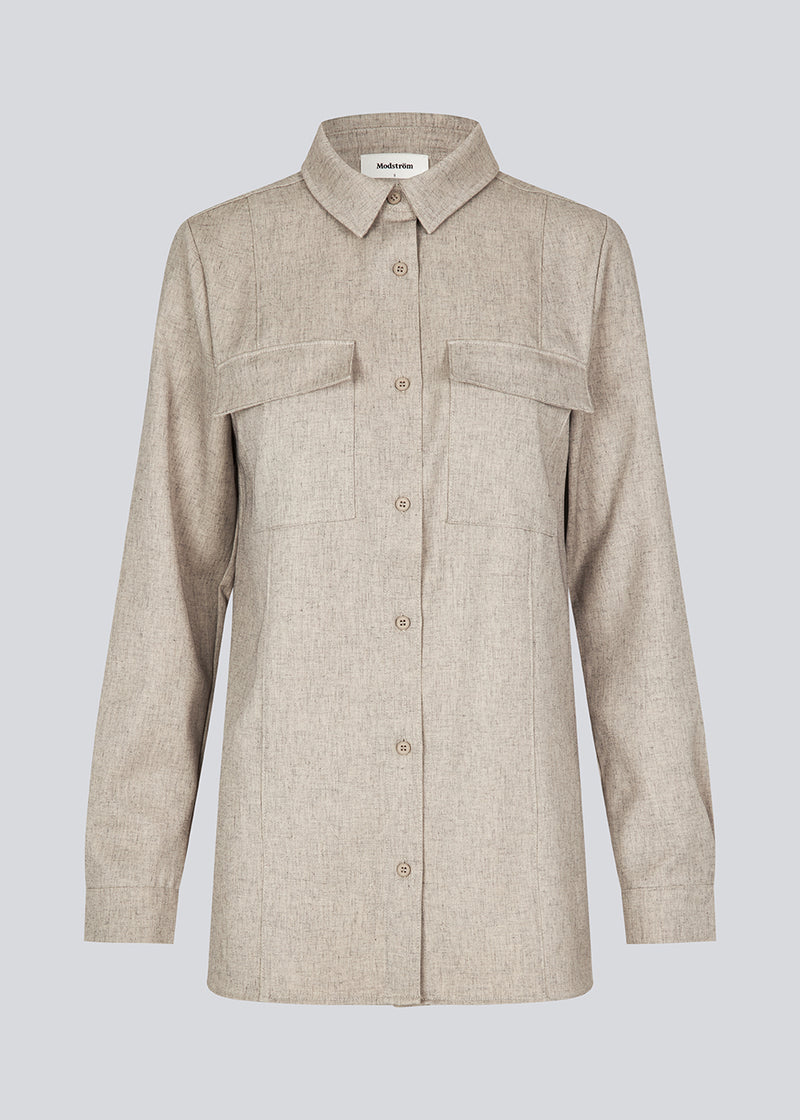 Beige long shirt with folded details in front. KalemMD shirt has two chest pockets, button closure in front and slits in the side seams.