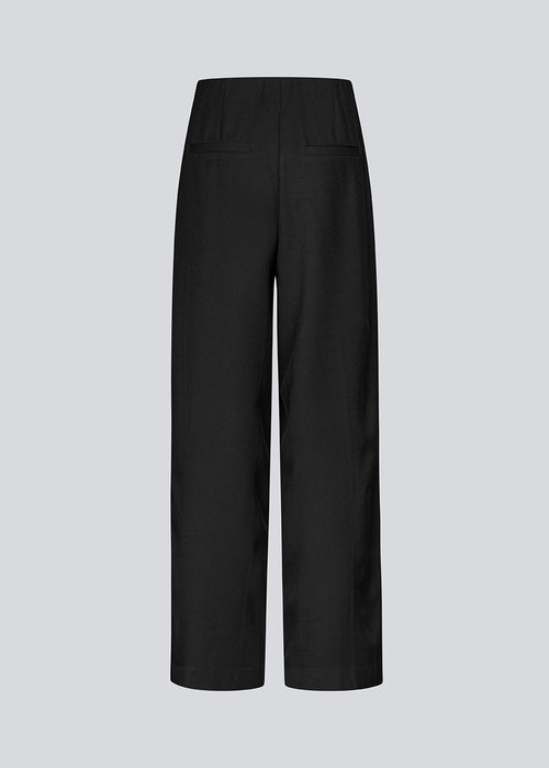 Loose black pants with stitched pintock. KammyMD pants has an invisible zipper, side pockets and an elastic waist.