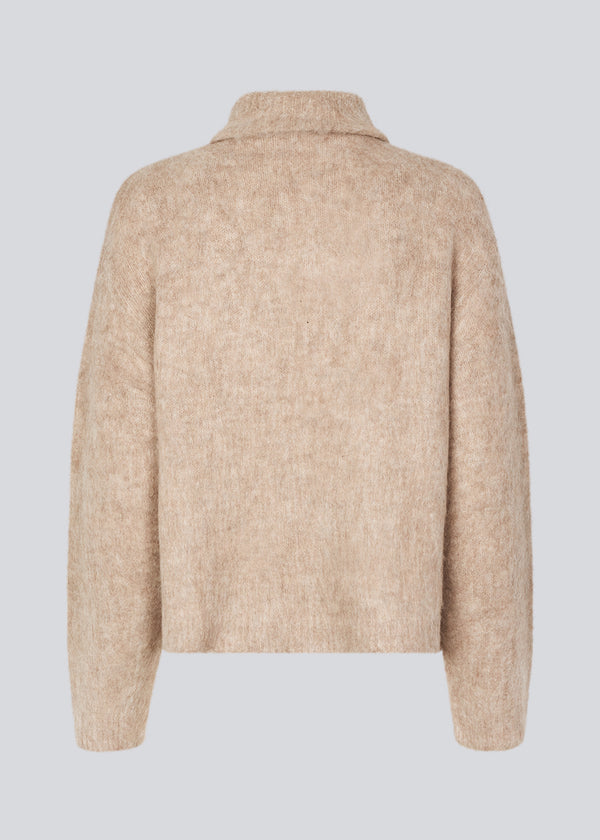 Soft beige knit with a high neck and half zip front. KaneMD v-neck has a loose fit and dropped shoulders.