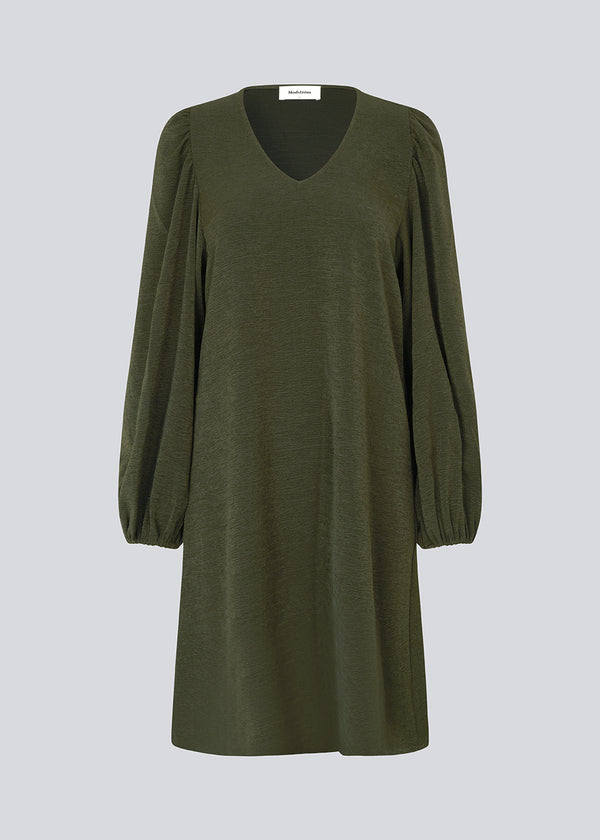 Dark green short dress in a light structured material. KarliMD short dress has puff sleeves and a V-neck.