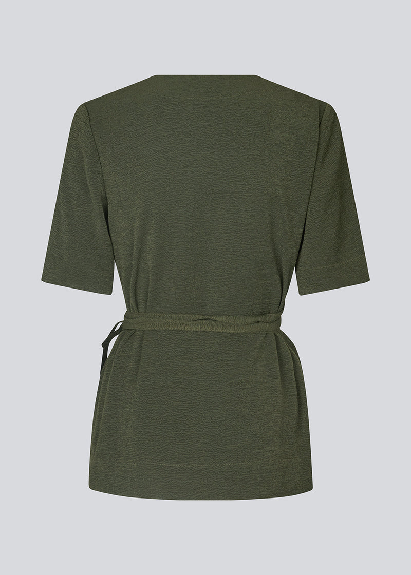 Wrap top with short loose sleeves in a dark green color. KarliMD top is closed in the side with a tieband.