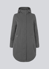 A warm water-repellent winter coat in grey with a high collar and hood. Keller coat has a hidden button and zipper closure at the front, along with zipped pockets. The coat has a relaxed silhouette with an adjustable elastic at the waist. The filling is a sustainable polyester padding with an extra high insulation ability.