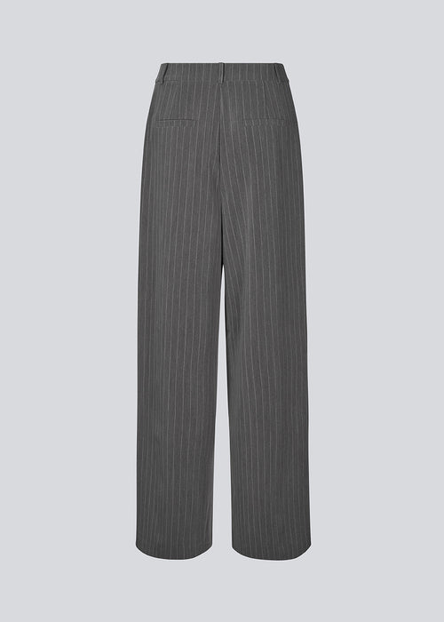 Pants in grey pinstripe with wide legs. KemmaMD pants has side pockets, a medium high waist, zipper and paspoil back pockets.