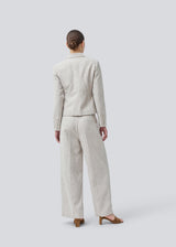 Short fitted blazer in beige melange in a structured material. KieraMD jacket has two pockets at the front and a slit at the sleeves with button closure.
