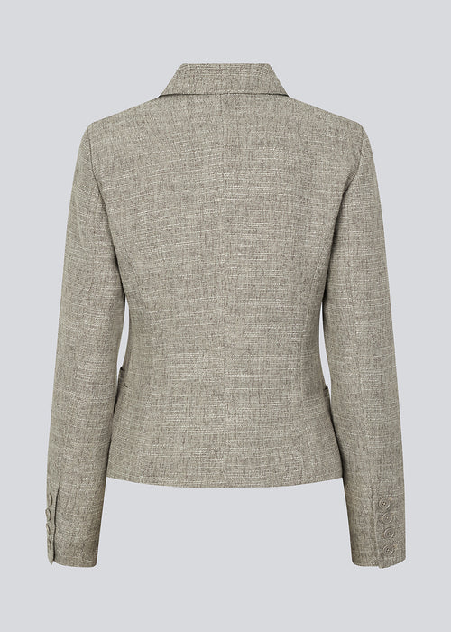 Short fitted blazer in a structured material. KieraMD jacket has two pockets at the front and a slit at the sleeves with button closure.