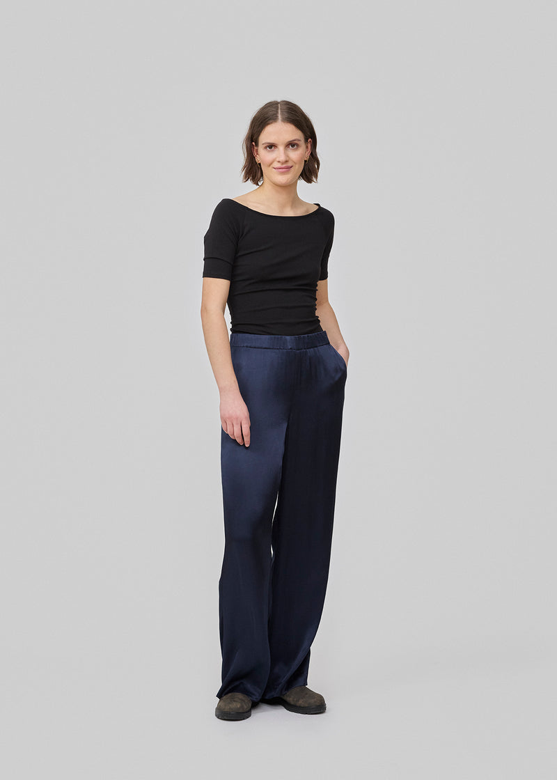 Loose pants in dark blue with wide legs in satin. KindleMD pants has side pockets and an invisible zipper on the side.