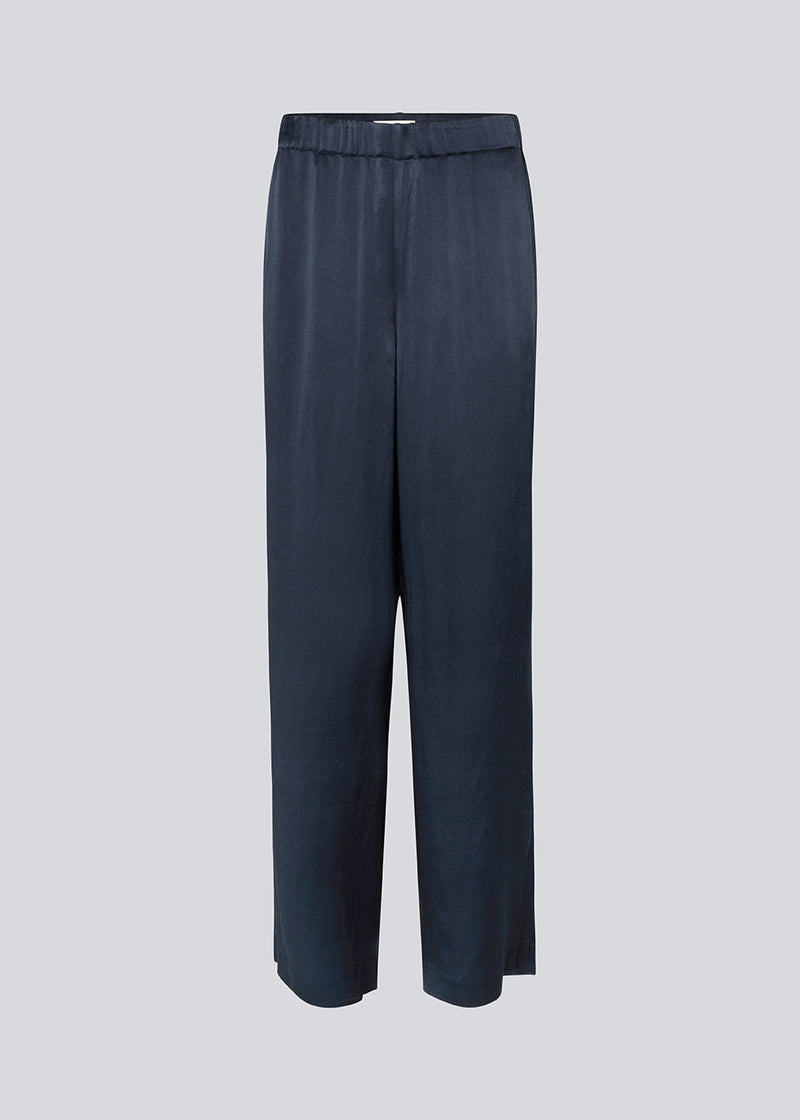 Loose pants in dark blue with wide legs in satin. KindleMD pants has side pockets and an invisible zipper on the side.