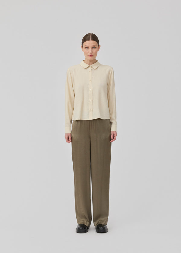 Loose pants in brown with wide legs in satin. KindleMD pants have side pockets and an invisible zipper on the side.