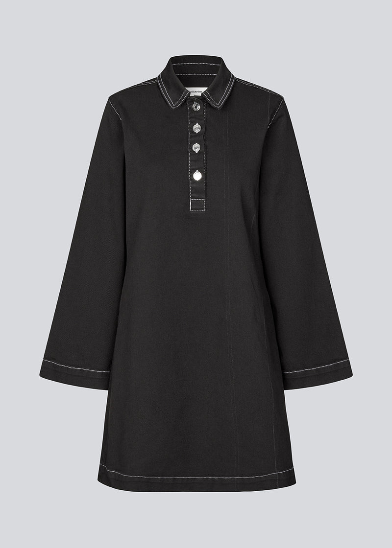 Short dress in denim with contrast stitching. KonradMD dress has a shirt collar, button closure in front and long wide sleeves.