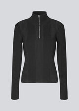 Fitted knit with a high neck. KrissaMD zip t-neck in Black is in rib knit and has a zipper in front.