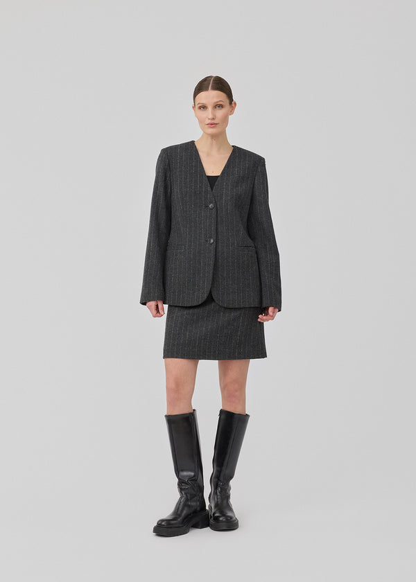 Fitted dark grey blazer in a pinstriped wool mix. KristolMD blazer has shoulder pads, two pockets in front, lining and a slit in the back.