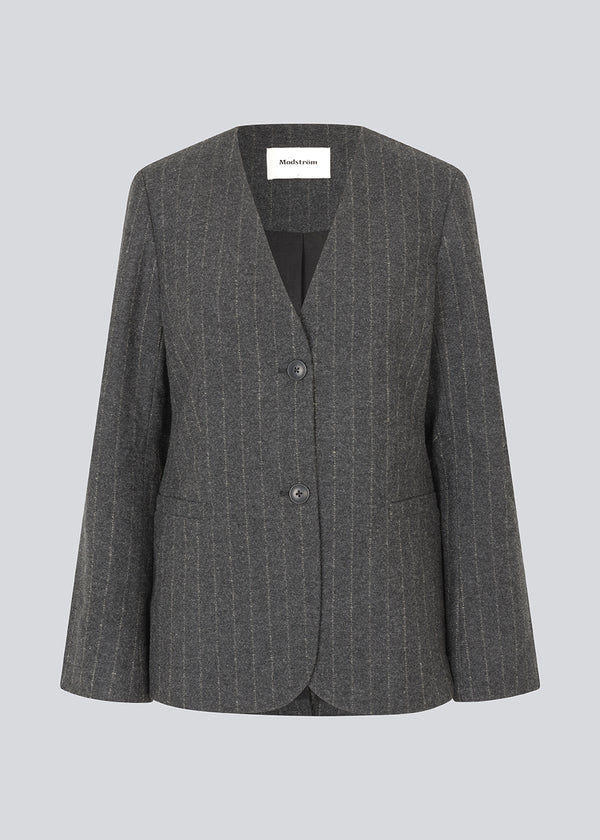 Fitted dark grey blazer in a pinstriped wool mix. KristolMD blazer has shoulder pads, two pockets in front, lining and a slit in the back.