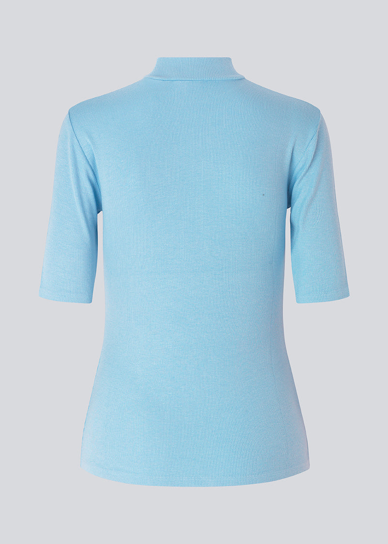 Short-sleeved t-shirt with a high neck in blue. Krown t-shirt is in a nice rib quality and has a tight fit. The t-shirt is of a nice Eco Verro Viscose quality. The model is 177 cm and wears a size S/36.