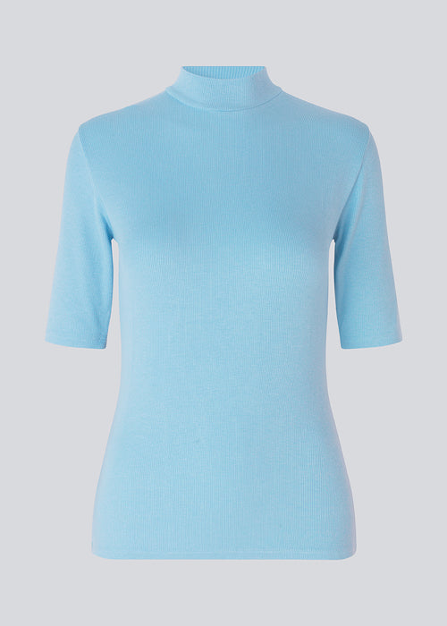 Short-sleeved t-shirt with a high neck in blue. Krown t-shirt is in a nice rib quality and has a tight fit. The t-shirt is of a nice Eco Verro Viscose quality. The model is 177 cm and wears a size S/36.