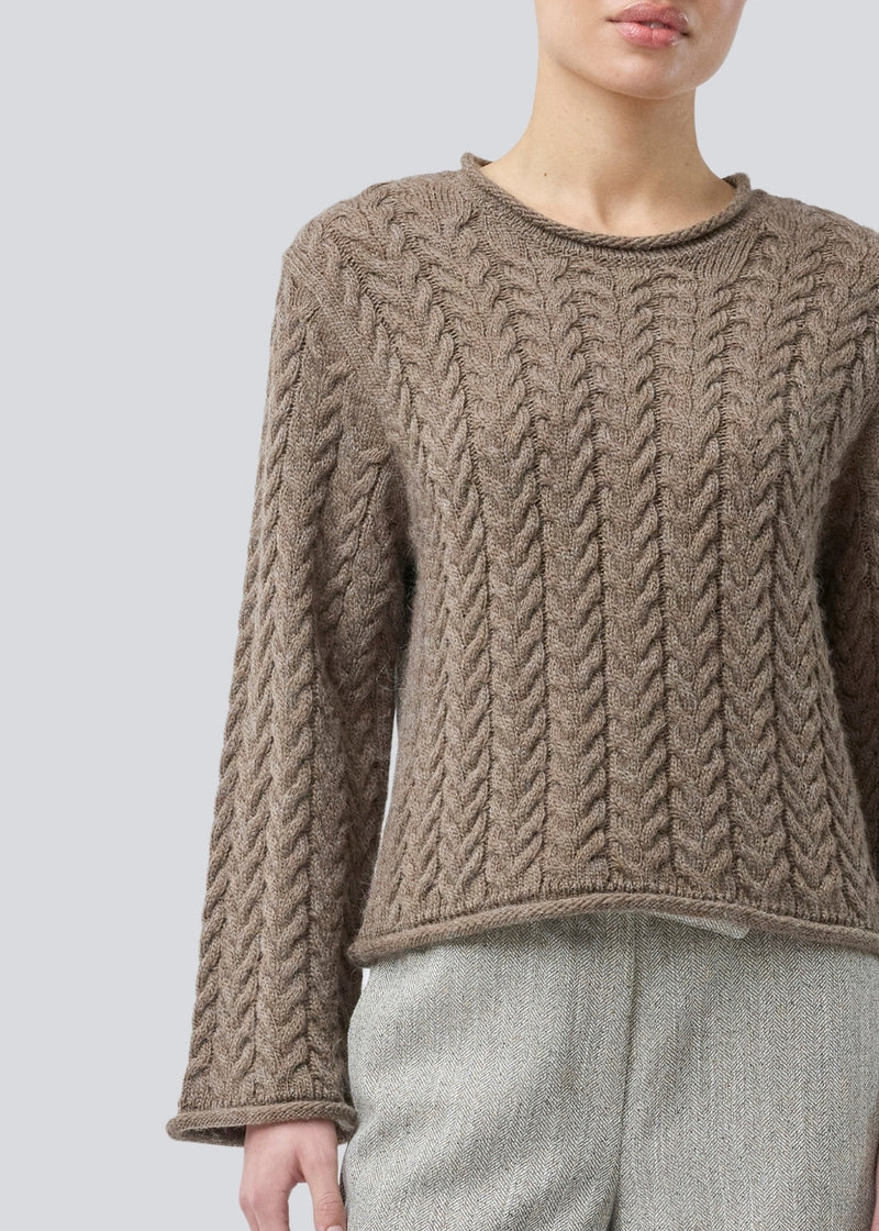 Loose knit with wide sleeves in cable knit. KurtisMD round neckline and rolled edges.
