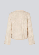 Loose creme knit with wide sleeves in cable knit. KurtisMD o-neck has a round neckline and rolled edges.