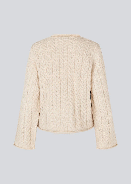 Loose creme knit with wide sleeves in cable knit. KurtisMD o-neck has a round neckline and rolled edges.