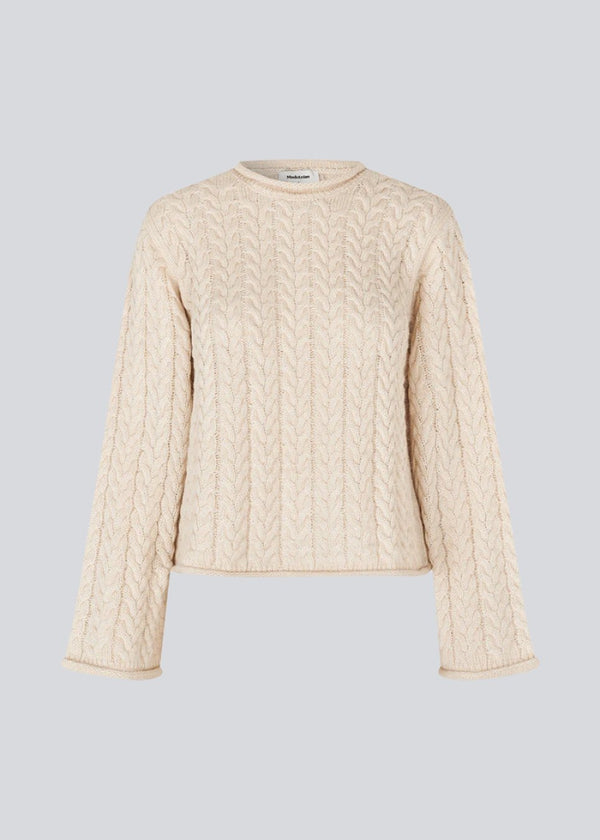 Loose creme knit with wide sleeves in cable knit. KurtisMD o-neck has a round neckline and rolled edges.