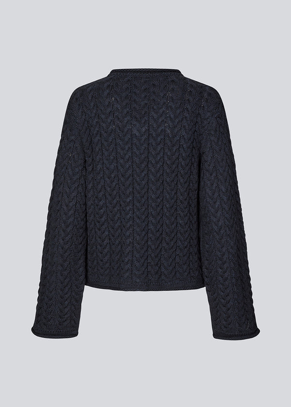 Loose wool knit in navy blue with wide sleeves. KurtisMD v-neck has a v-neck and rolled edges.