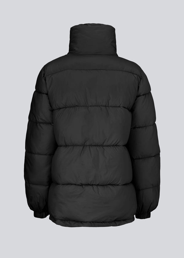 A modern winter coat in black with a cool puffer design. Kyle coat has a high collar and big pockets at the front. The filling is 100% recycled polyester, which makes it possible to keep warm down to -10 degrees.
