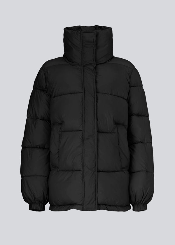 A modern winter coat in black with a cool puffer design. Kyle coat has a high collar and big pockets at the front. The filling is 100% recycled polyester, which makes it possible to keep warm down to -10 degrees.