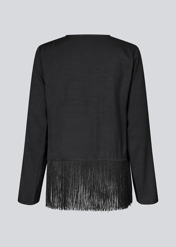 Black top with long sleeves in twill and a fringe detail. KylerMD shirt has a V-neck and loose sleeves.