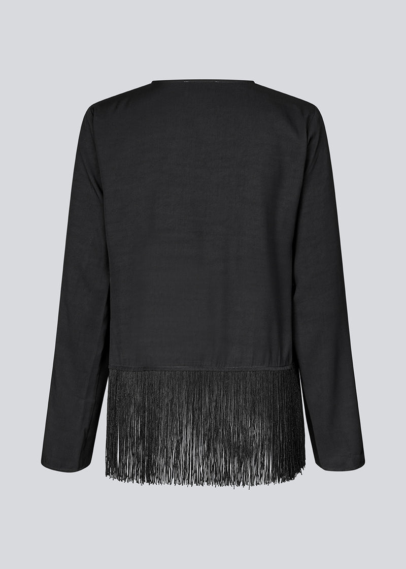 Black top with long sleeves in twill and a fringe detail. KylerMD shirt has a V-neck and loose sleeves.