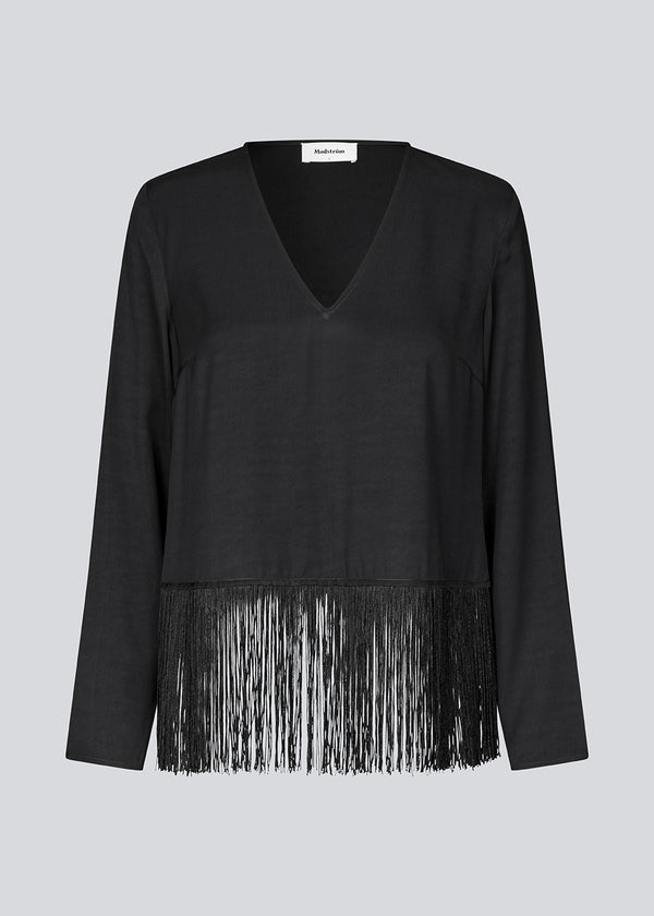 Black top with long sleeves in twill and a fringe detail. KylerMD shirt has a V-neck and loose sleeves.