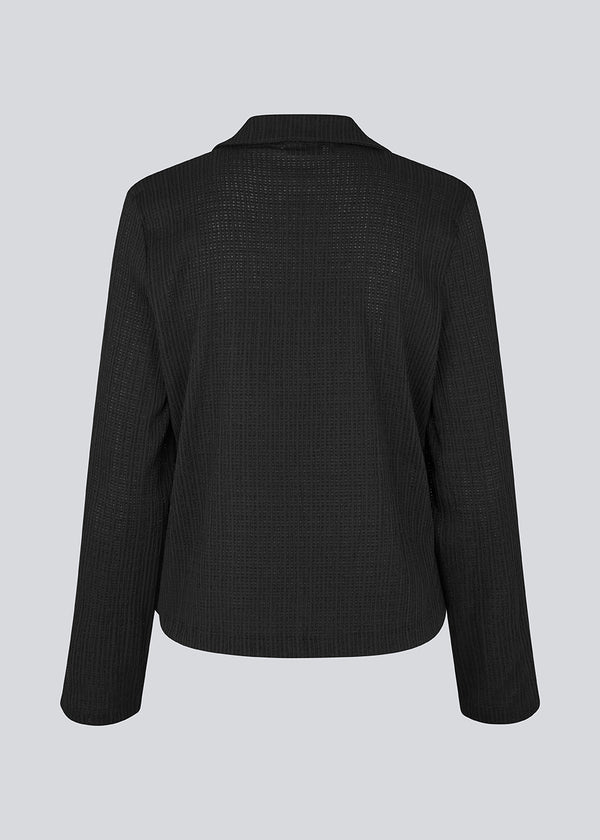 Classic shirt with tieband closure in an elastic and slightly see-through material. LaceyMD shirt has wide sleeves with slits and tree tiebands in front.