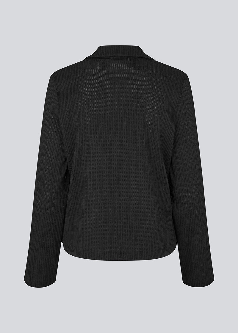 Classic shirt with tieband closure in an elastic and slightly see-through material. LaceyMD shirt has wide sleeves with slits and tree tiebands in front.