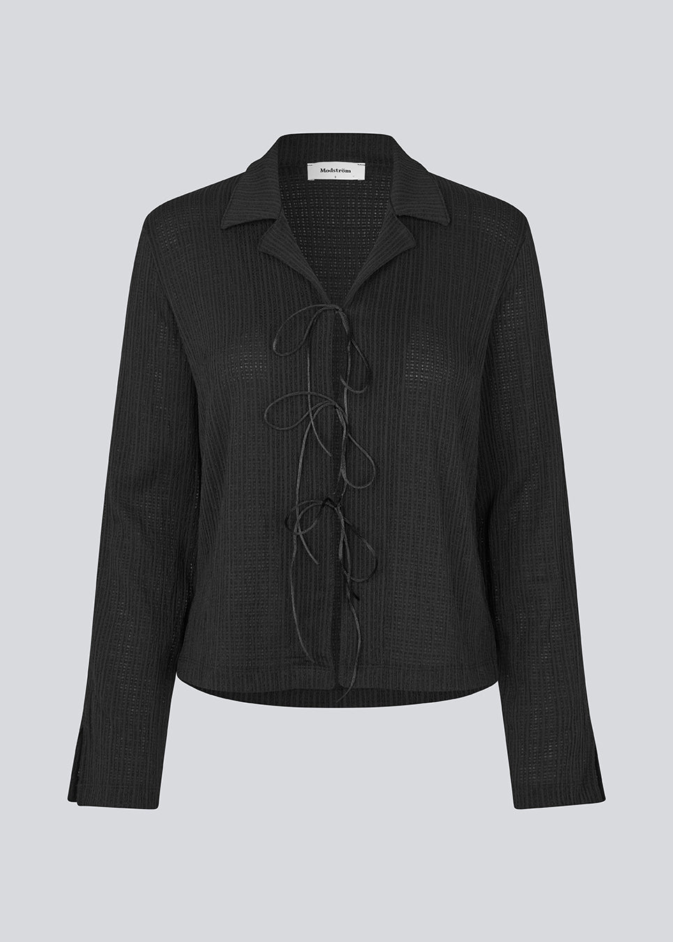 Classic shirt with tieband closure in an elastic and slightly see-through material. LaceyMD shirt has wide sleeves with slits and tree tiebands in front.
