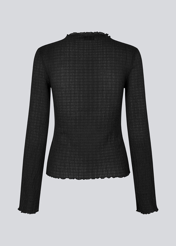 Longsleeved black top in an elastic and slighly see-through material. LaceyMD is fitted and has a high neck.