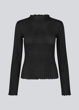 Longsleeved black top in an elastic and slighly see-through material. LaceyMD is fitted and has a high neck.