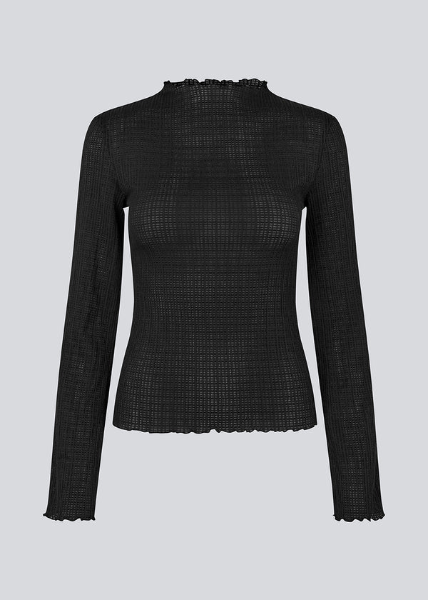 Longsleeved black top in an elastic and slighly see-through material. LaceyMD is fitted and has a high neck.