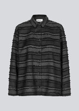 Black shirt in fringed polyester. LiljaMD shirt has a cuf with buttonclusre, a classic shirtcollar and a button closure in front.