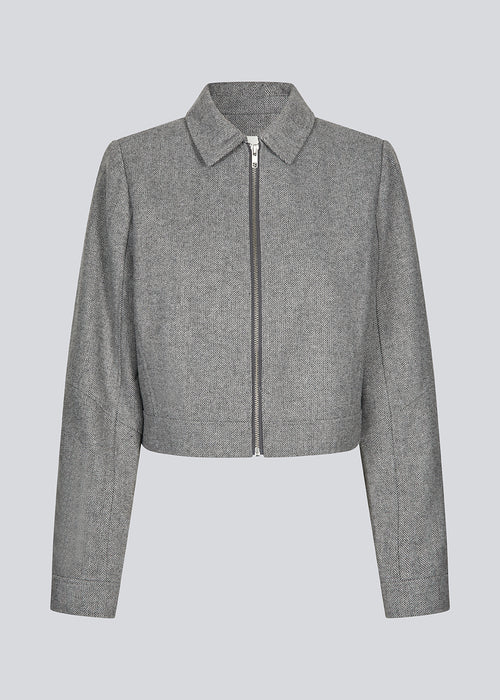 Cropped grey jacket in 80% wool. LissieMD jacket has a classic collar, manchet with button closure and a zipper in front. The model is 177 cm and wears a size S/36.