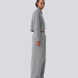 Grey suit pants in a 80% wool with wide legs. LissieMD pants has a high waist, zipper, side pockets and paspoil pockets in the back.