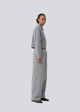 Grey suit pants in a 80% wool with wide legs. LissieMD pants has a high waist, zipper, side pockets and paspoil pockets in the back.