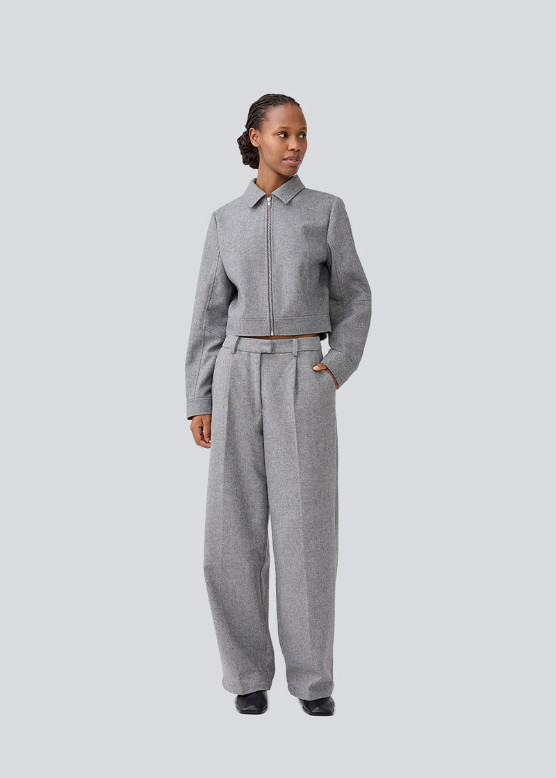 Grey suit pants in a 80% wool with wide legs. LissieMD pants has a high waist, zipper, side pockets and paspoil pockets in the back.