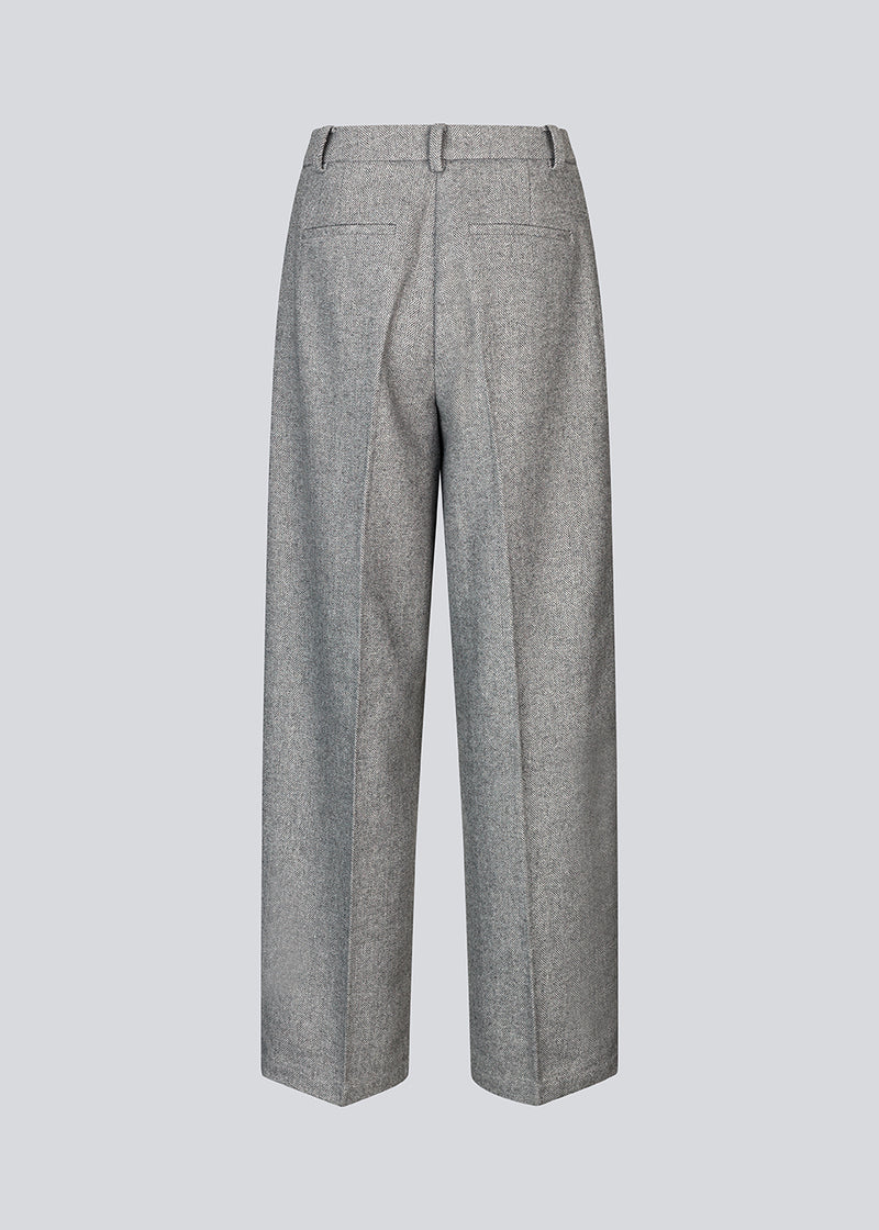 Grey suit pants in a 80% wool with wide legs. LissieMD pants has a high waist, zipper, side pockets and paspoil pockets in the back.