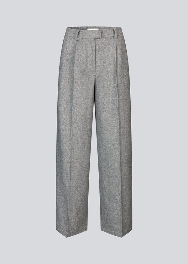 Grey suit pants in a 80% wool with wide legs. LissieMD pants has a high waist, zipper, side pockets and paspoil pockets in the back.