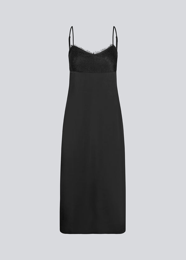 Long black dress in satin with a lace detail on the chest and an open back. LivMD dress is fitted, has thin adjustable straps and a slit in the side.